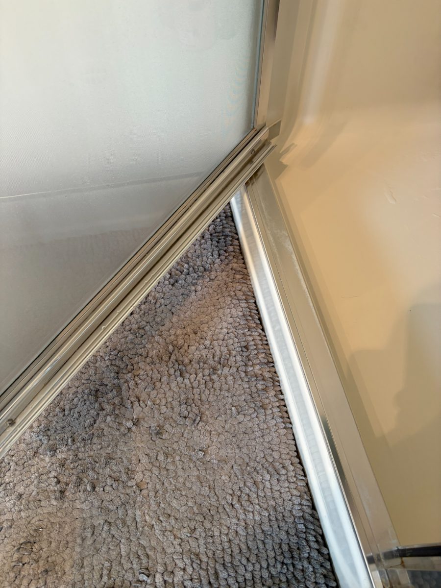 The same shower door track spotless after cleaning