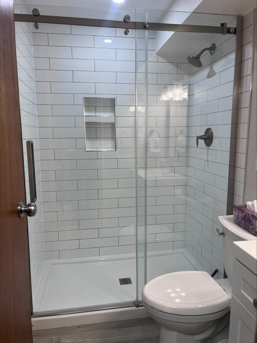 A spotless tiled shower with polished glass door in a Saskatoon home